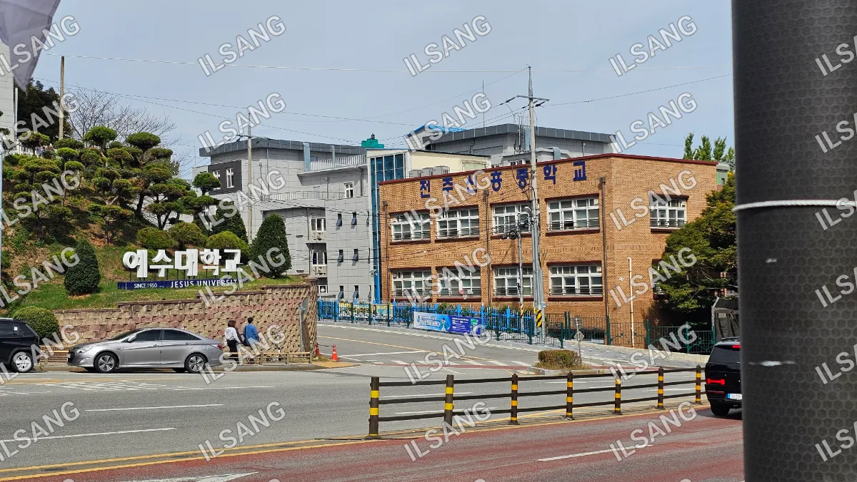 A street with a brick building and a fence.