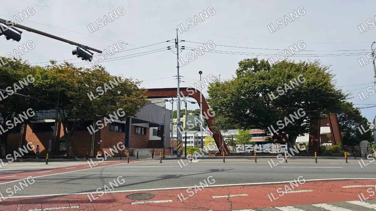 A street with a red crosswalk and a bridge over the road.