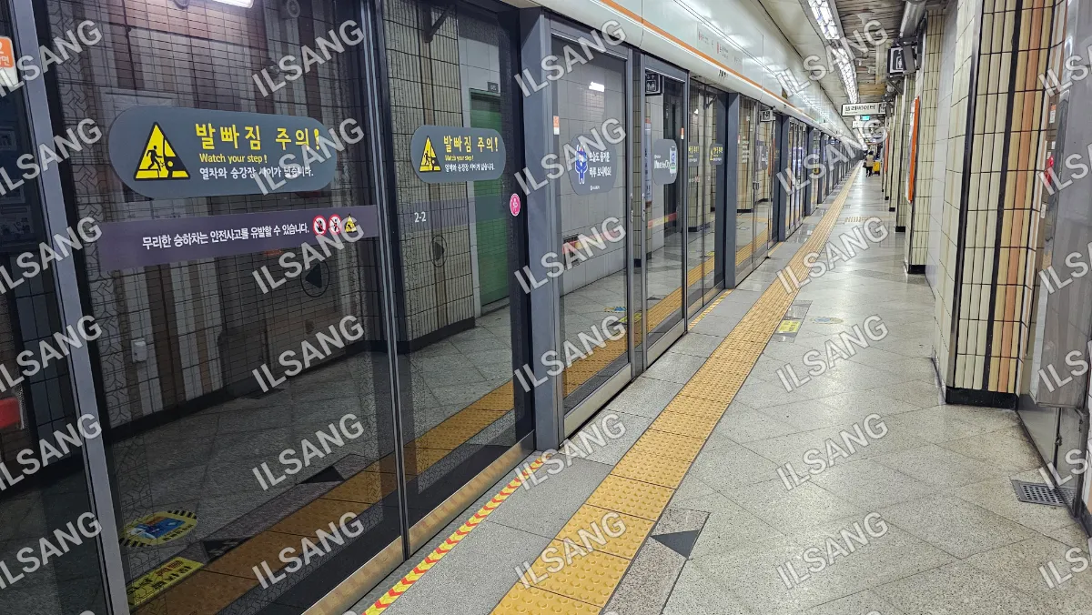 A train station with a yellow line on the floor.