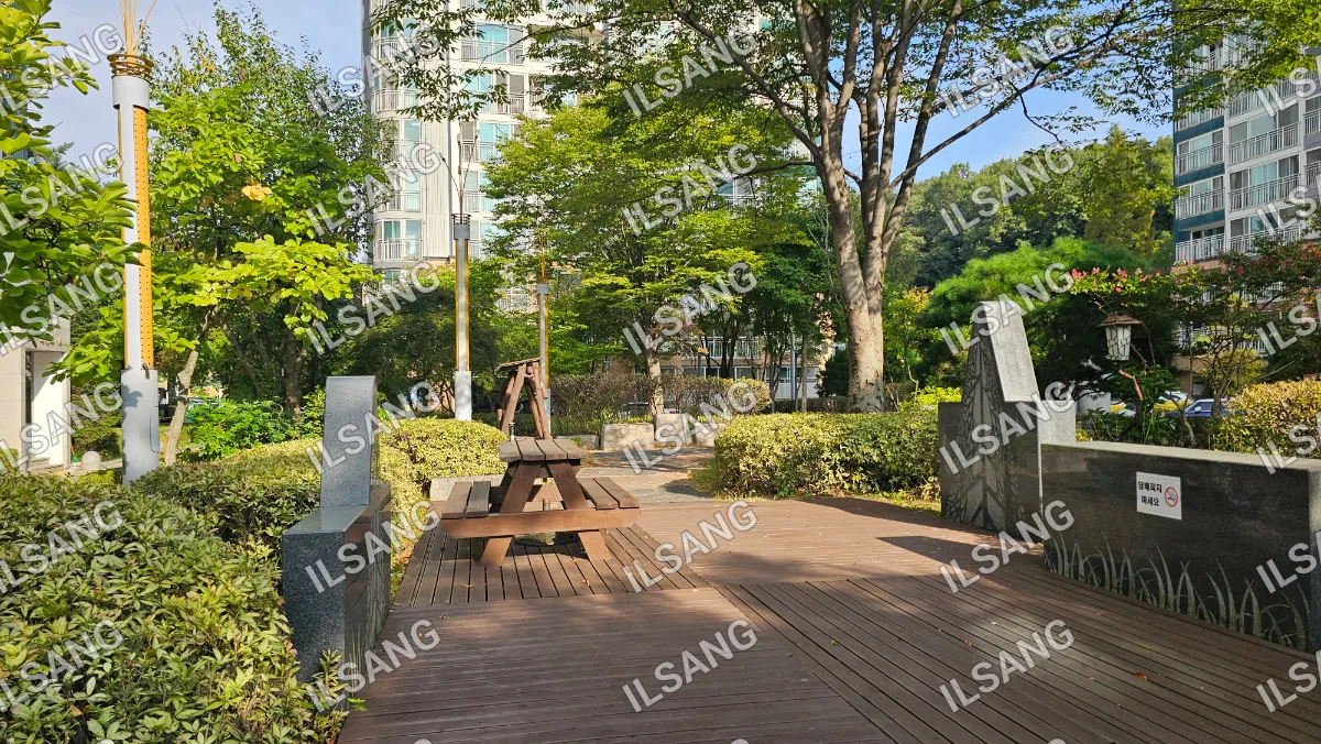 A wooden bench is situated in a park with a tree in the background.