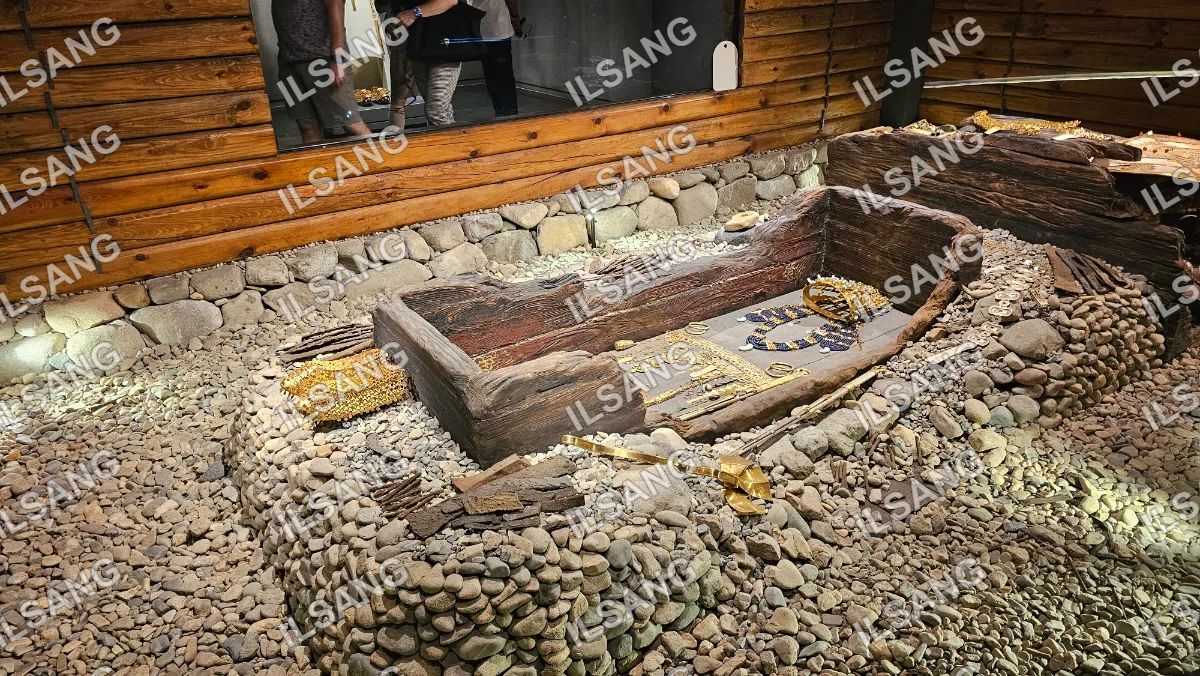 A wooden boat with gold jewelry and a snake on it.