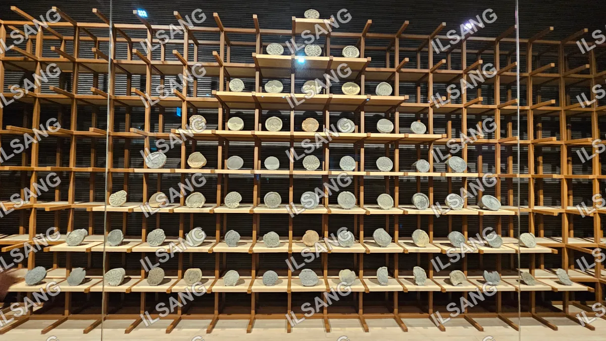 A wooden display case with a variety of different sized rocks in it.