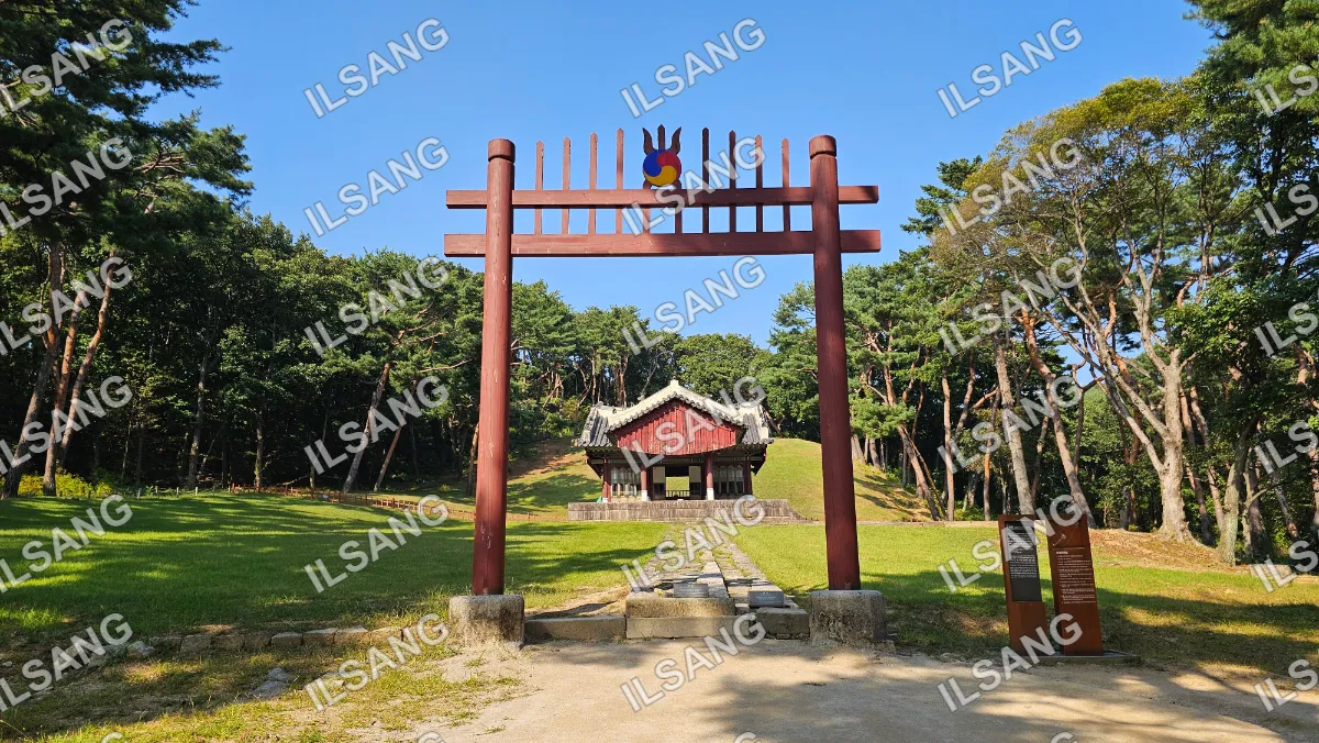 A wooden structure with a red roof and a blue and yellow sign on top.