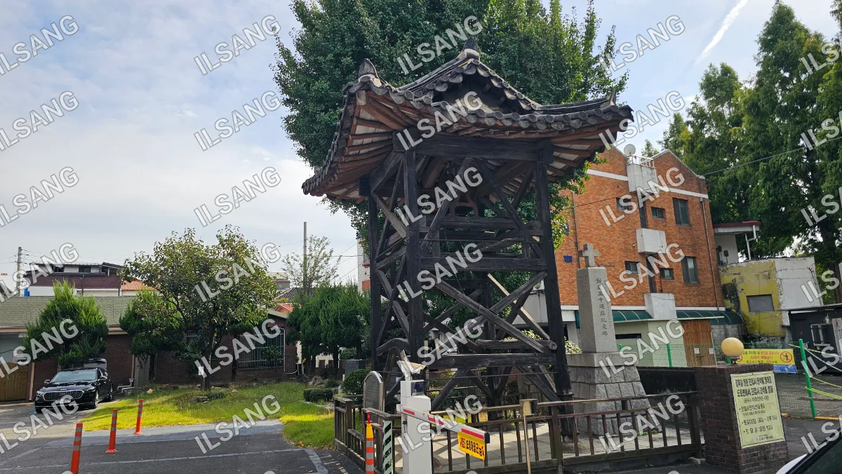 A wooden structure with a roof and a cross on top.