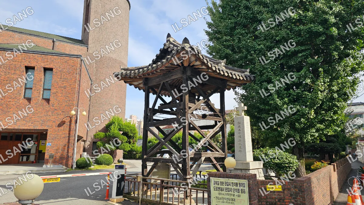 A wooden structure with a roof and a sign in front of it.