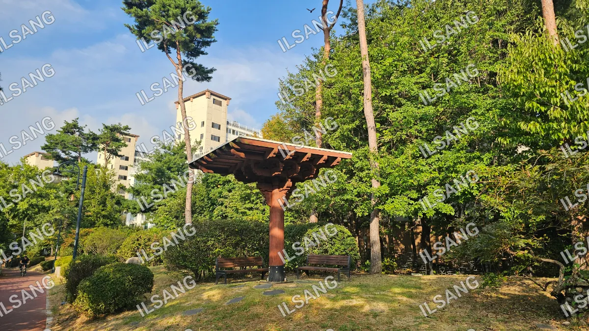 A wooden structure with a roof in a park.