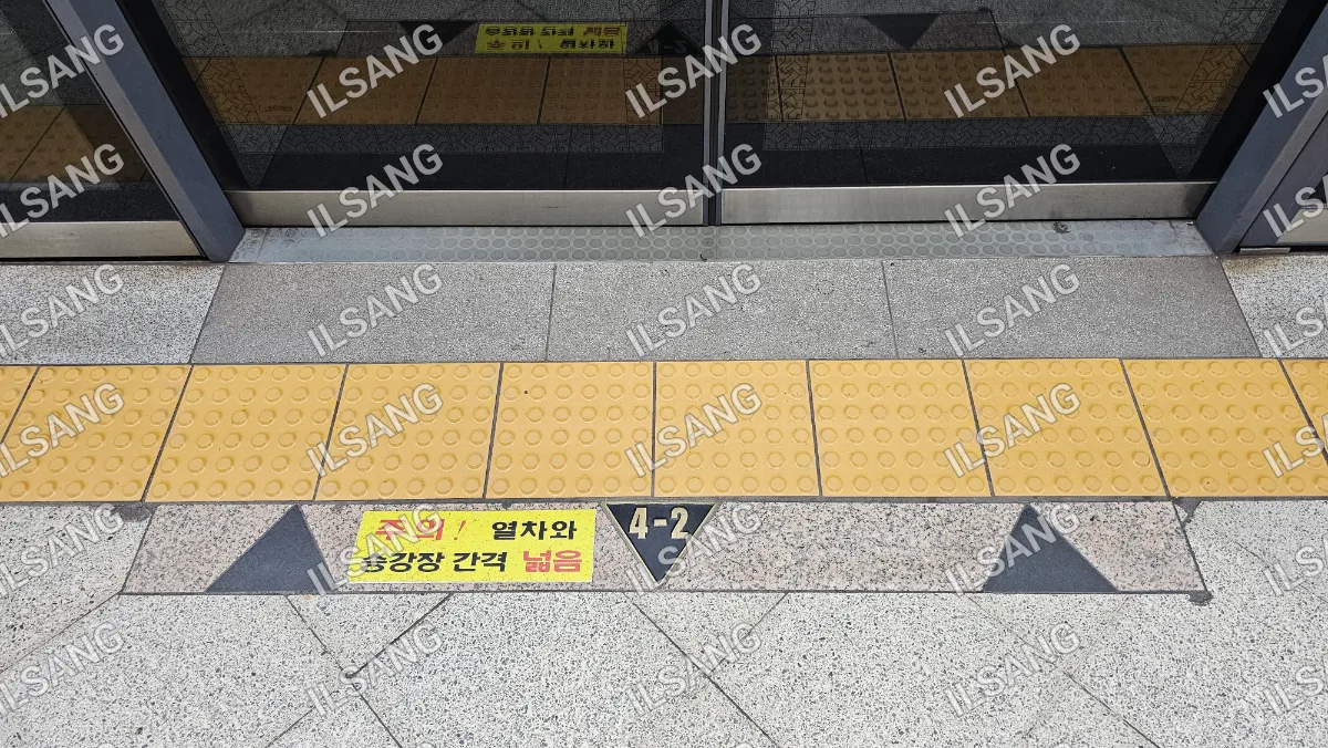 A yellow and black sign with a triangle on it.