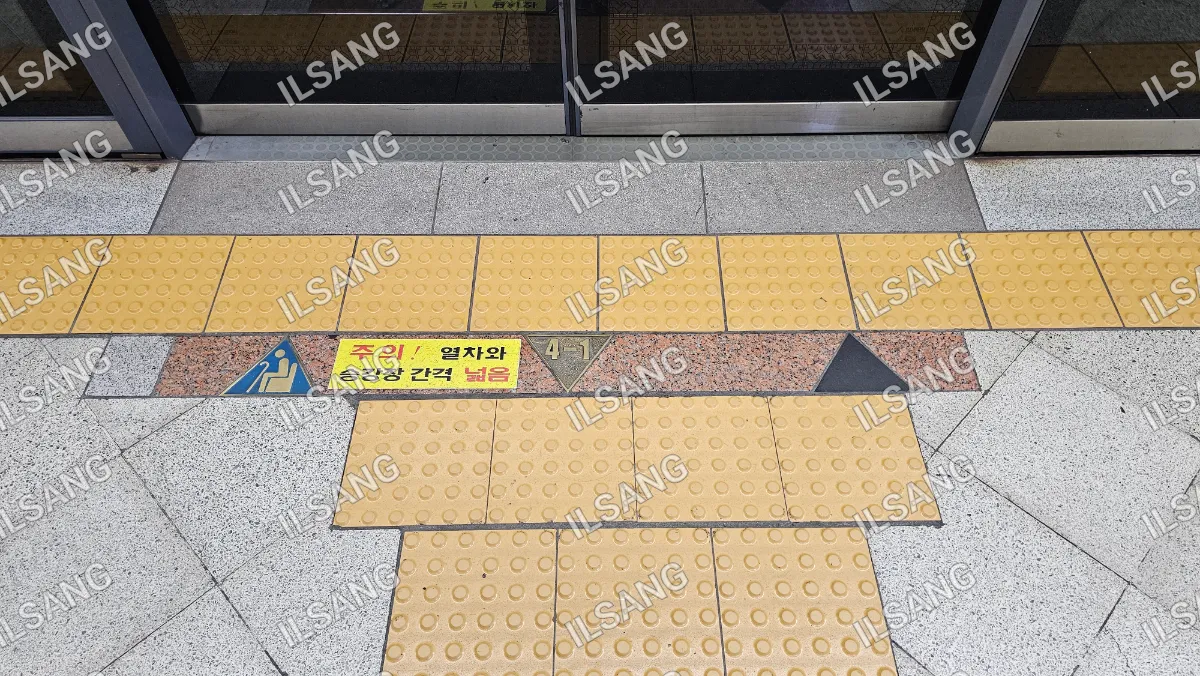 A yellow and black tile floor with a sign in a foreign language.