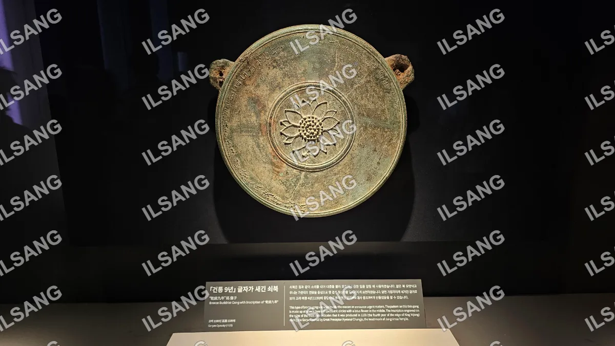 An ancient bronze bowl with a flower design on it.