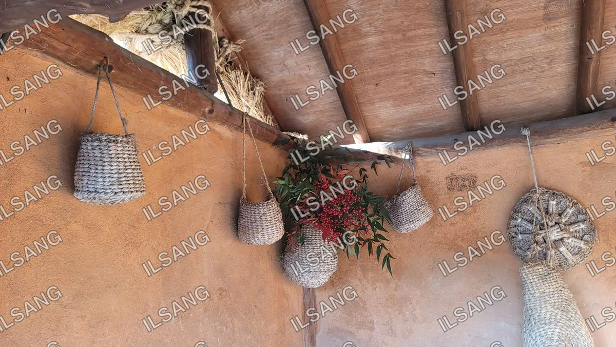 A wall with two woven baskets hanging from it.