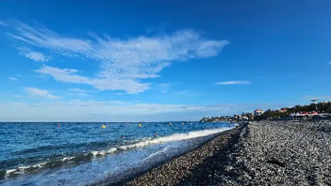 A beach scene with a few people and a boat