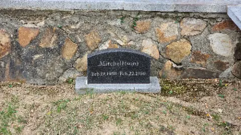 A black and white headstone for a man named Mitchell