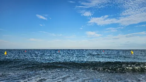 A blue sky with clouds and a body of water