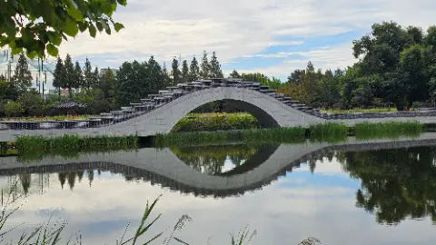 A bridge over a pond with a reflection of the