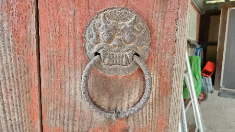 A bronze door knocker with a dragon face on it