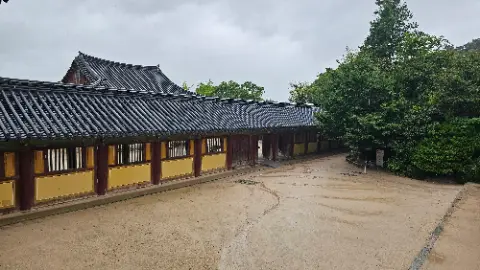 A building with a roof and a fence in front
