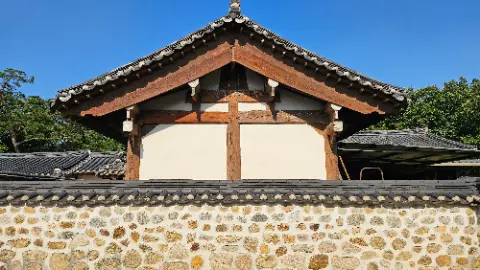 A building with a wooden roof and stone walls