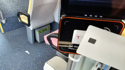 A cell phone is attached to a pink seat on