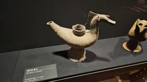 A clay sculpture of a dragon is on display