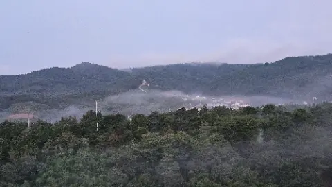 A foggy mountain with a church on top