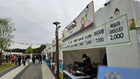 A food stand with a woman cooking in front of