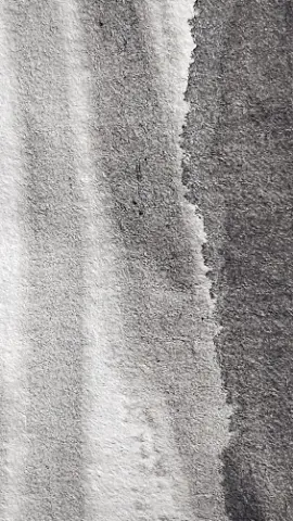 A gray and white cloth with a tear in it
