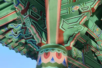 A green and red roof with a red pillar