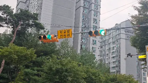 A green traffic light is hanging from a wire above