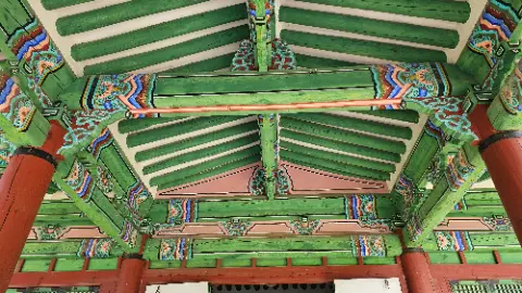 A green wooden ceiling with a cross beam