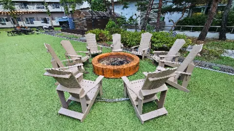 A group of chairs are arranged around a fire pit