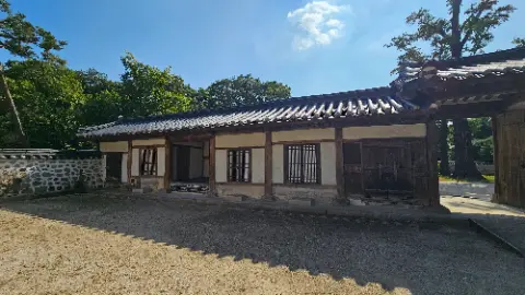 A house with a white roof and a black gate