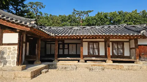 A house with a wooden roof and a stone wall