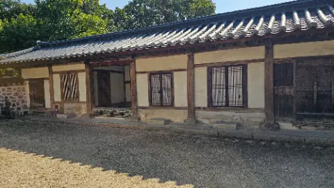 A house with a wooden roof and a stone wall