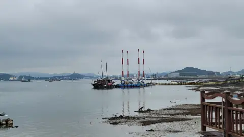 A large boat is docked at a pier in a