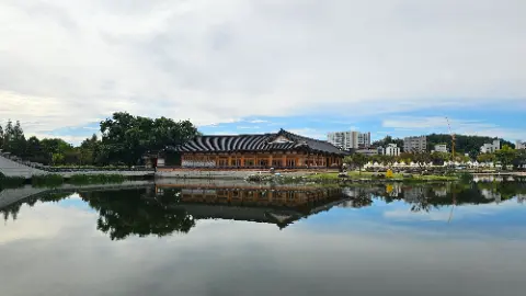 A large building with a pagoda roof is reflected in