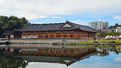 A large building with a reflecting pool in front of