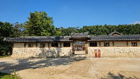 A large building with a stone wall and a wooden