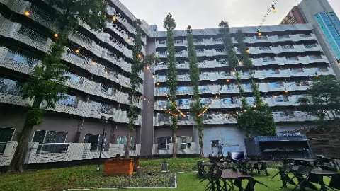 A large building with many lights and trees in front