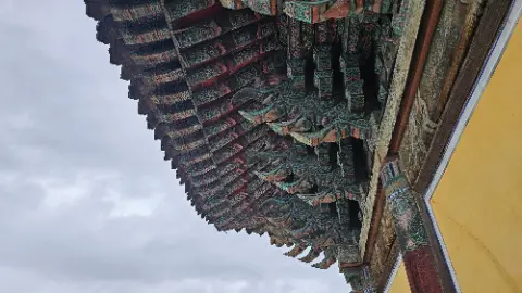 A large green and red roof with many decorative designs