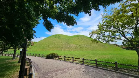 A large hill with a green grassy area and a