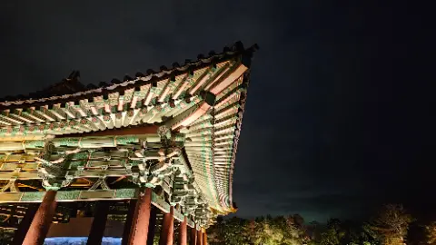 A large oriental building with a green roof and a