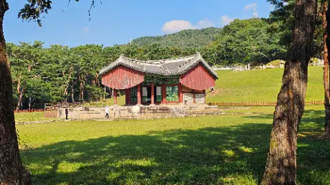 A large red building with a white roof and green
