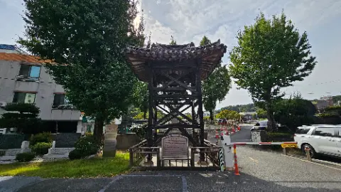 A large wooden structure with a roof and a sign