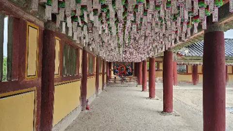 A long hallway with a red roof and a red