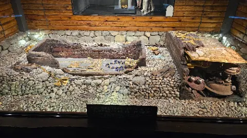 A museum exhibit of a wooden boat with gold and