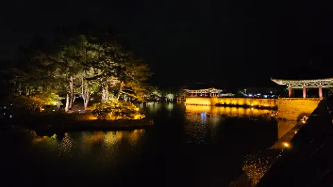 A nighttime scene of a lake with a building in
