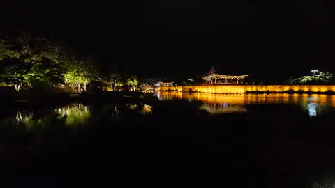 A nighttime view of a lake with a building in
