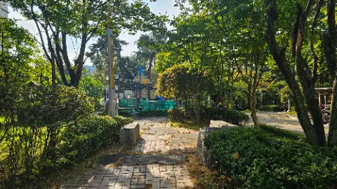 A park with a playground and a small pavilion