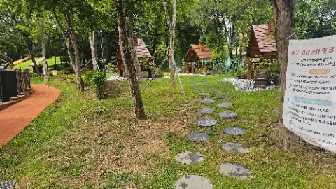 A pathway with a few small houses and a bench