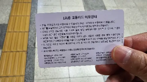 A person is holding a card with foreign writing on